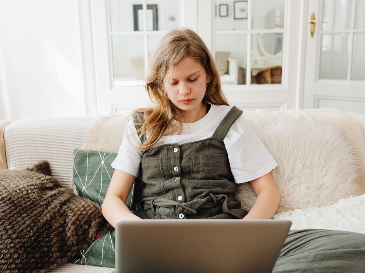 A secondary-school student studying confidently on a laptop at home — the calm focus the GCSE programme builds.